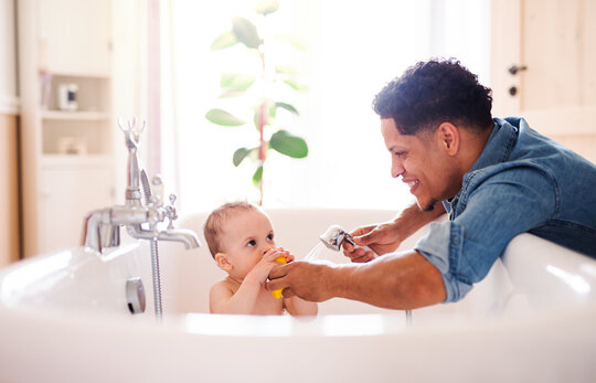Bild: Vater wäscht Kind in Badewanne