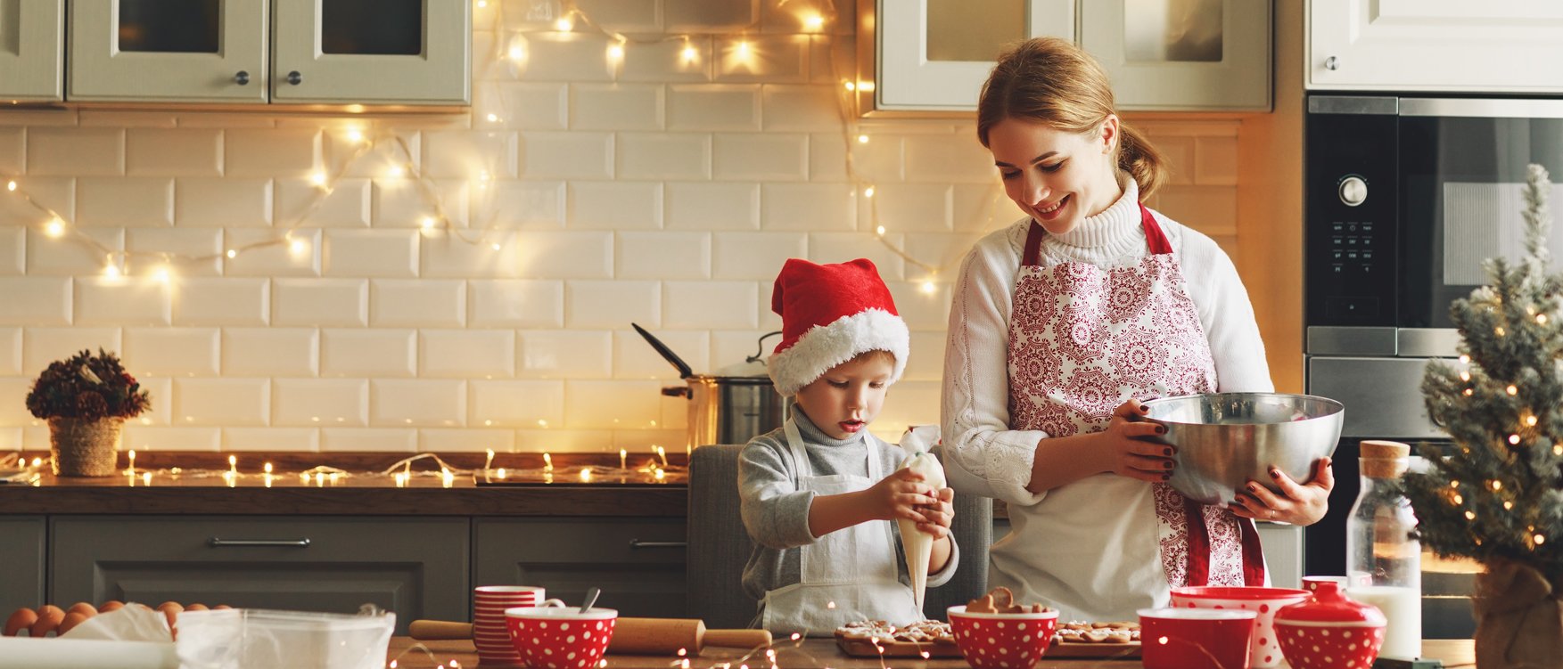 Mutter backt mit ihrem Kind zu Weihnachten Plätzchen