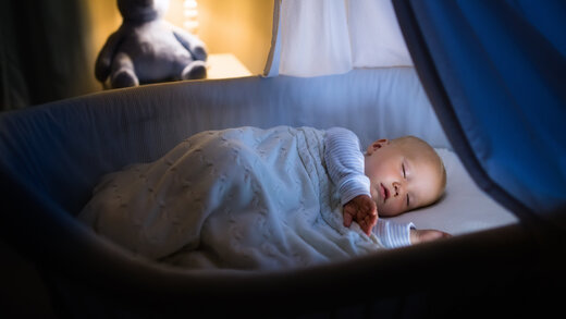 Ein Baby schläft in einem Stubenwagen oder Kinderbett