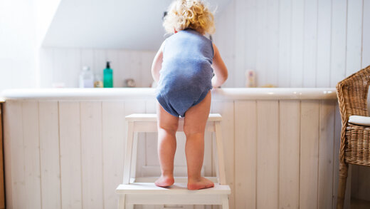 Ein kleines Kind beugt sich über Badewanne