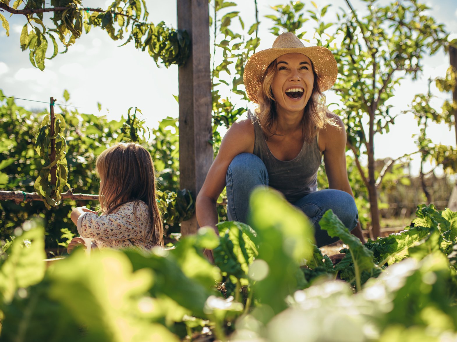 Junge Frau mit Sonnenhut im Garten