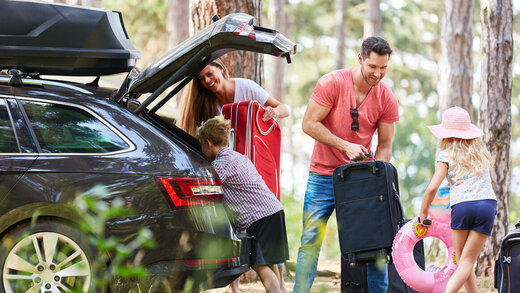 Familie packt das Auto für den Urlaub.