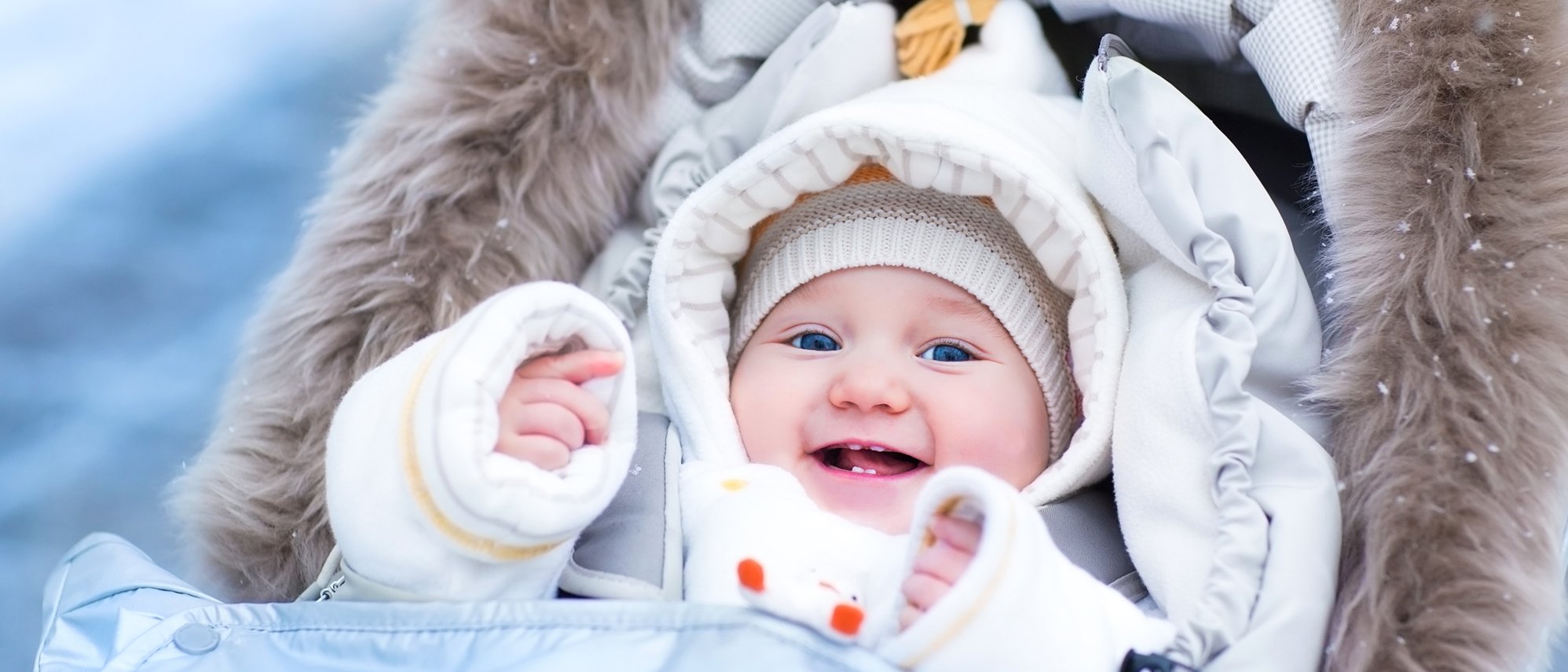 Baby sitzt warm eingepackt im Kinderwagen