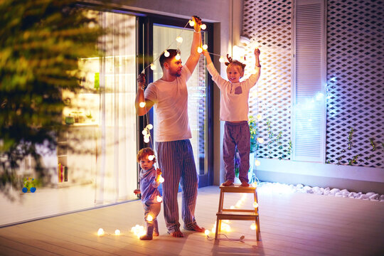 Familie hängt sichere Lichterketten für draußen auf