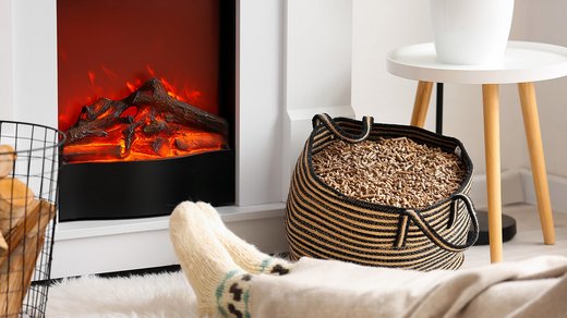 Holzpellets in einem Sack vor einem Kamin. Pellets sollten richtig gelagert werden, damit es nicht zur Vergiftung kommt.