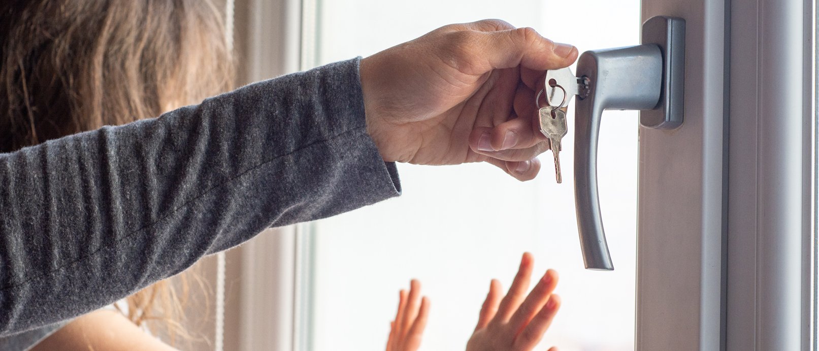 Aufsichtsperson verriegelt das Fenster durch ein Fensterschloss