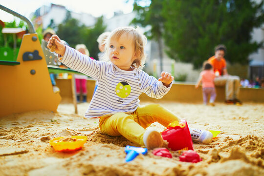 Kleinkind im Sandkasten auf dem Spielplatz