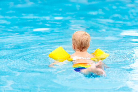 Kind mit Schwimmflügeln im Pool