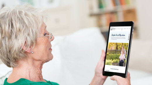 Seniorin liest auf einem Tablet die Webseite der Aktion Das sichere Haus