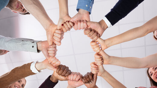 Eine Gruppe von Menschen bildet mit ihren Händen einen Kreis
