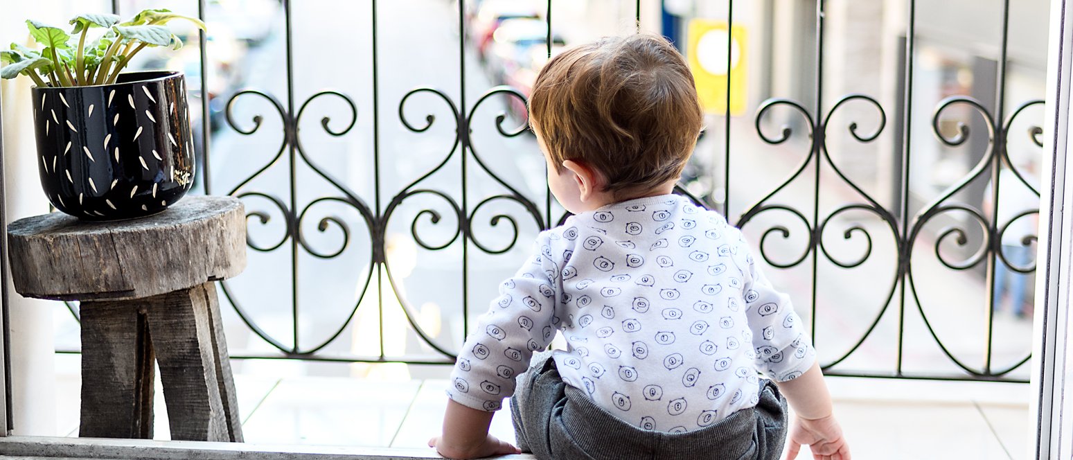 Kleinkind sitzt ohne Aufsichtsperson auf dem Balkon