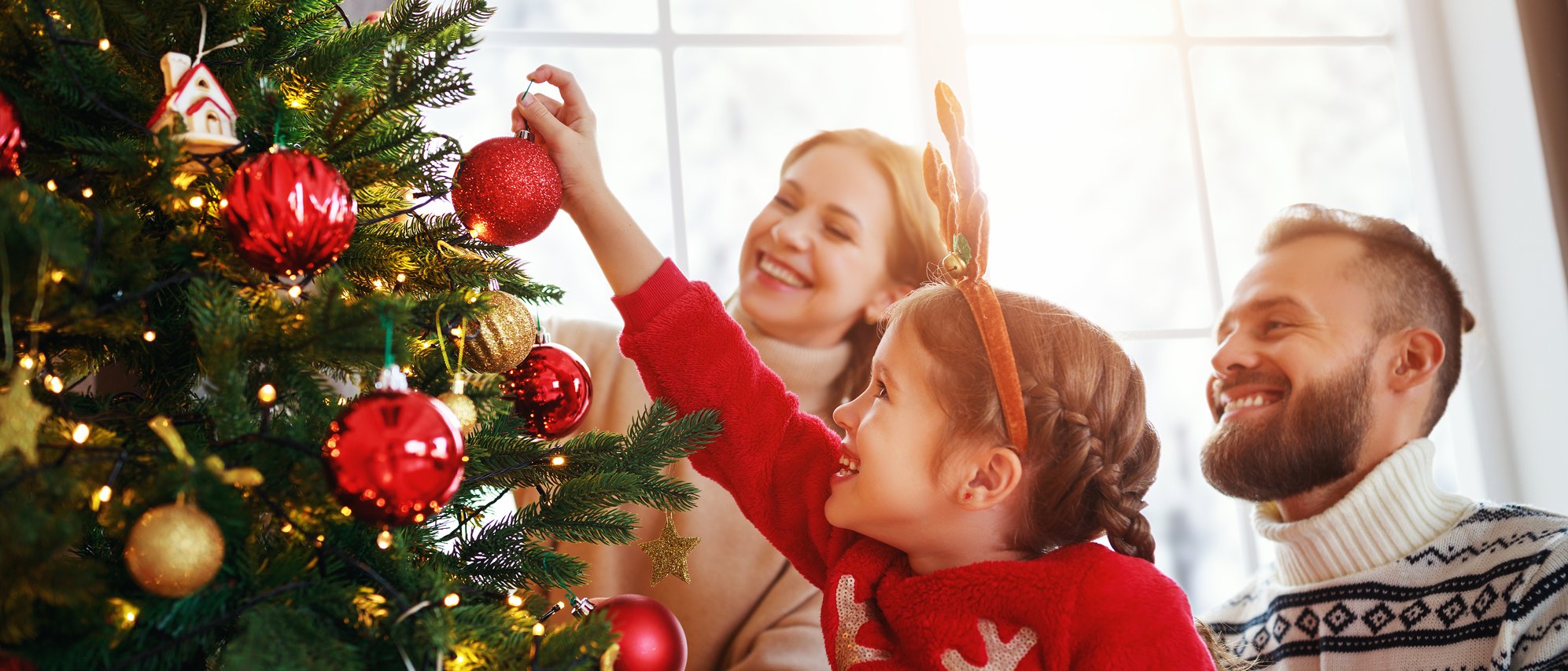 Familie schmückt ihren Weihnachtsbaum