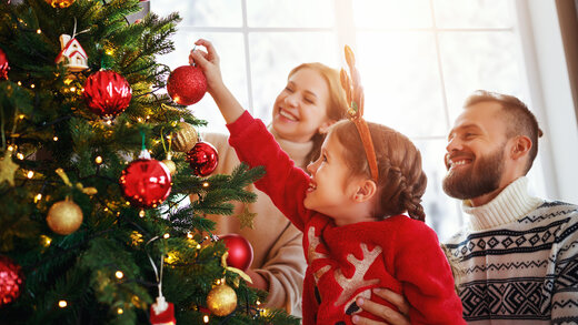 Familie schmückt einen Weihnachtsbaum