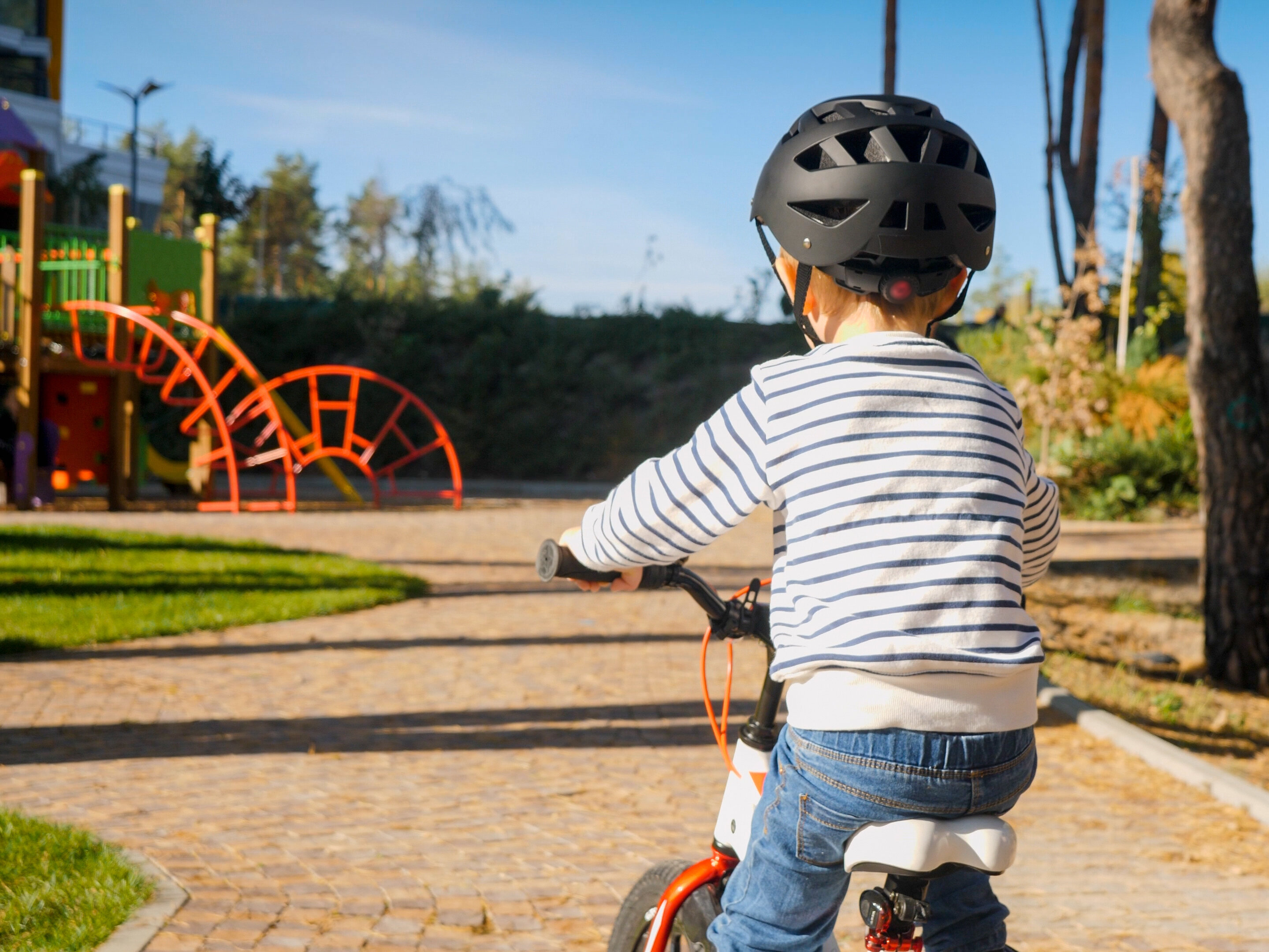 Bild: Kind mit Helm auf einem Spielplatz