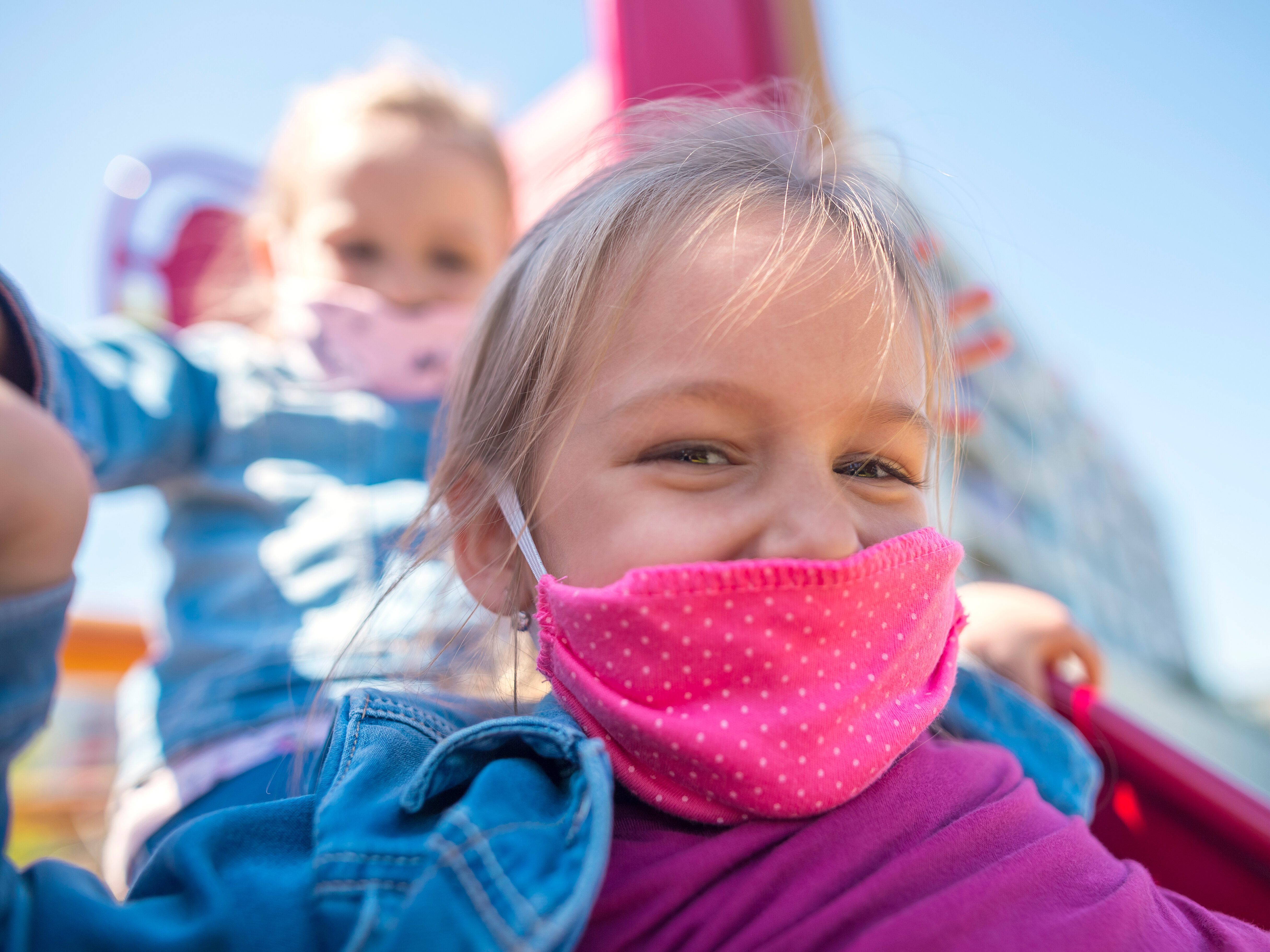 Bild: Kind spielt in der Corona-Pandemie mit einem Mund-Nase-Schutz auf dem Spielplatz