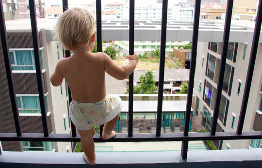 Kleinkind in einer gefährlichen Situation auf dem Balkon