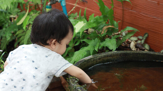 Kind an einer Wasserstelle im Garten