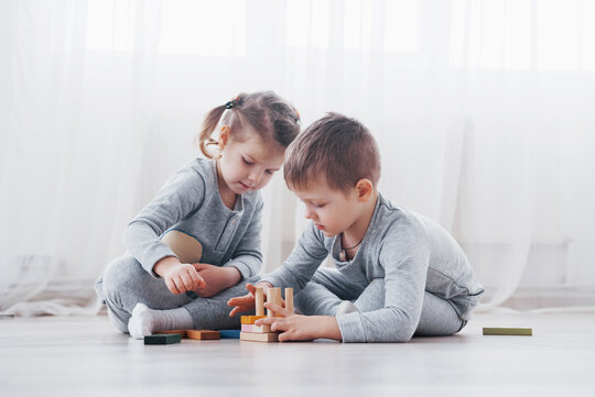 Bild: Zwei Kinder spielen mit Bauklötzen in der Wohnung