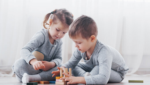 Zwei kleine Kinder spielen mit Bauklötzen