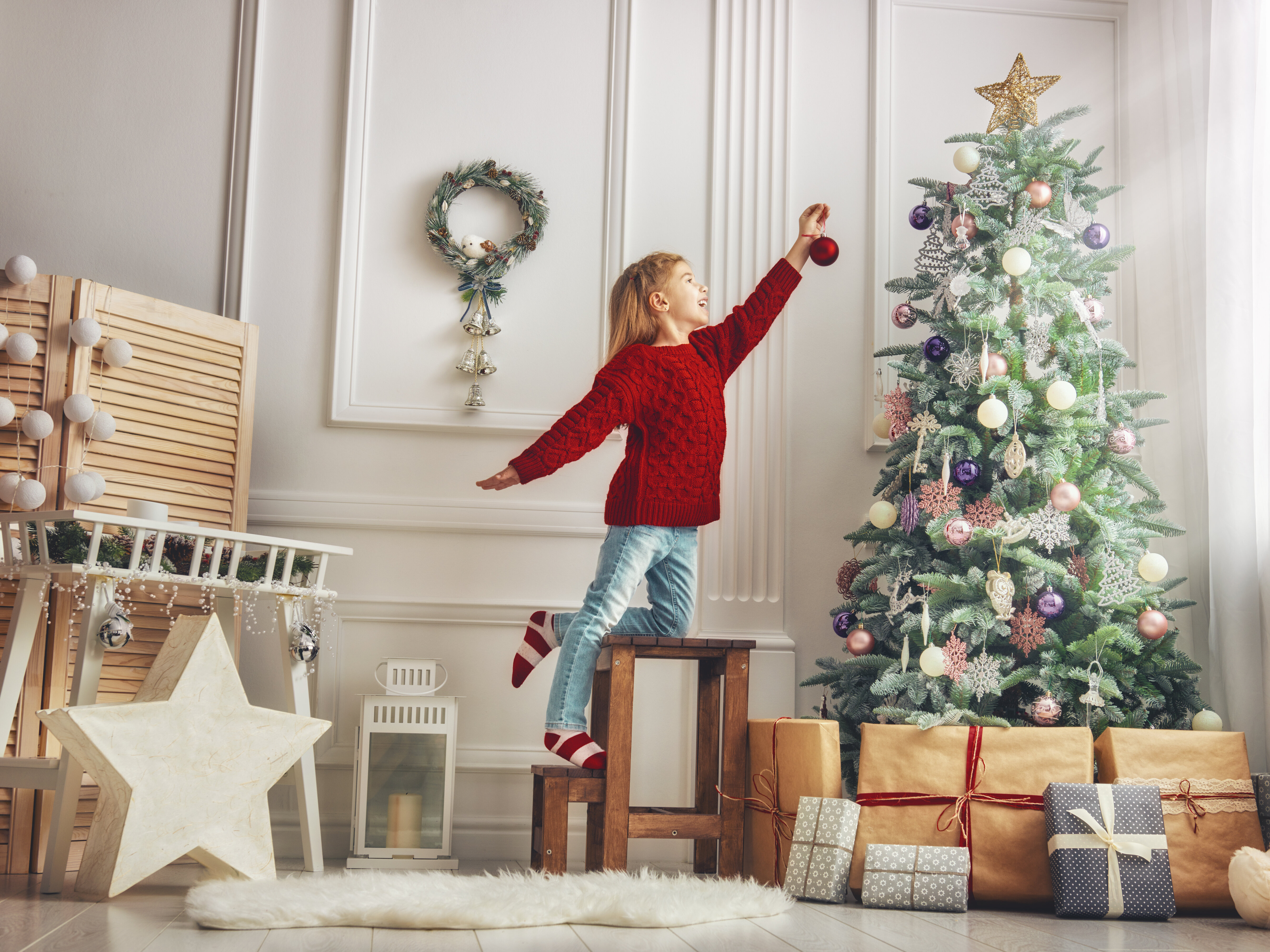 Mädchen schmückt einen Weihnachtsbaum